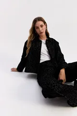 Campera de corte clásico con cuello camisero y cierre frontal de botones, confeccionada en tejido de algodón con textura en relieve de animal print.