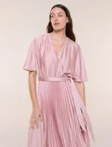 Vestido maxi de satén color rosado, con escote en V cruzado, mangas cortas amplias, cintura elastizada con lazo de ajuste y falda plisada con forro interno.