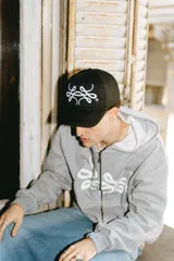 Gorra trucker negra con logo bordado en blanco, de diseñador y materiales de alta calidad.