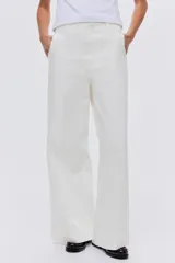 Pantalón de jean blanco de corte wide leg y tiro alto, con diseño de pierna amplia, bolsillos laterales al bies y raya marcada en el frente.