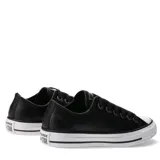 Championes Converse modelo Chuck Taylor All Star de corte bajo, confeccionados en cuero negro con textura granulada. Presentan puntera de goma blanca, cordones negros a tono y suela de goma vulcanizada con la clásica franja negra.