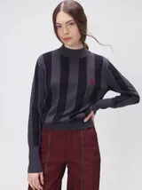 Sweater de punto con cuello polera, diseño a rayas verticales en tonos azules y logo bordado en color amarillo en el pecho. Presenta puños y ruedo ajustados.