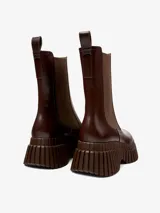 Botín Chelsea de cuero color marrón chocolate, con elásticos laterales y tirador trasero. Plataforma con suela de goma con diseño acanalado.