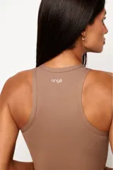 Top deportivo de cuello alto y espalda nadador, confeccionado en poliamida premium con alta elasticidad. Presenta recortes frontales diseñados para realzar la silueta y cuenta con forro interno para mayor soporte.