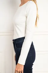 Remera de manga larga en color crudo, con cuello bote y corte ajustado al cuerpo.