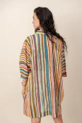Vestido corto camisero con estampado de rayas multicolores, cuello camisero, mangas tres cuartos y cierre frontal de botones.