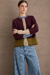 Cardigan de punto con diseño color block en tonos bordó, verde oliva y beige. Presenta cuello redondo con detalle en celeste, cierre frontal con botones y puños acampanados en color beige.