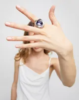 Anillo plateado con cristal rectangular facetado color morado.