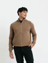 Cardigan de punto color marrón, con cuello alto y cierre frontal completo. Presenta mangas largas tipo ranglan y bolsillos laterales de ribete.