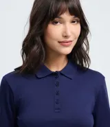 Blusa tipo polo de manga larga confeccionada en algodón, con cuello clásico y cierre frontal de botones. Presenta un diseño de corte regular y acabado suave.
