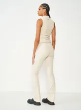 Blusa beige de cuello alto y corte ajustado, sin mangas y confeccionada en tejido de punto acanalado.