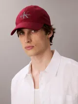 Gorra de béisbol Calvin Klein Jeans de color bordó, con visera curva y logo de la marca bordado en el frente en color gris.