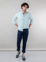 Camisa celeste de corte clásico, con cuello abotonado, manga larga y logo bordado en el pecho.