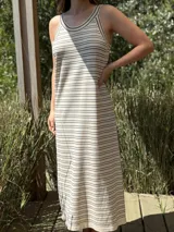 Vestido largo tejido a rayas horizontales blancas y negras, de corte recto y sin mangas.