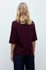 Sweater de punto color ciruela, con cuello redondo, mangas 3/4 y corte holgado.