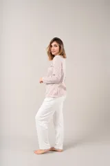 Pijama de dos piezas con estampado floral en tonos rosados y celestes sobre fondo blanco. La camisa es de manga larga con cuello mao y cierre frontal con botones. El pantalón es largo y de corte recto.