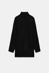 Vestido corto de punto suave con cuello subido, manga larga y sisa ancha. Presenta un detalle de costura central marcada en el delantero y acabados en rib en cuello, puños y ruedo.