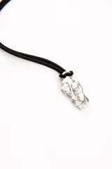 Colgante con dije plateado abstracto y cordón negro.