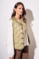 Chaleco verde militar con diseño acolchado y cierre frontal con botones.