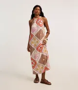 Vestido midi evasé de Marfinno, sin mangas y con cuello halter. Confeccionado en viscolino con estampado tropical de rombos y motivos playeros.