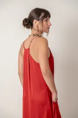 Vestido largo rojo de seda con escote en V y breteles finos. Diseño holgado con bolsillos laterales.