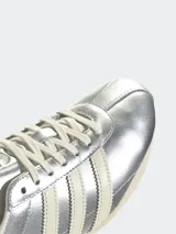 Zapatillas Adidas Tokyo color plateado con las tres tiras laterales en color crema.