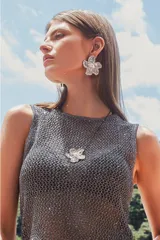 Set compuesto por collar y aros a juego con diseño de flor metálica plateada con centro de perla. El collar incluye una cadena fina y los aros son de tipo clip o pasante.