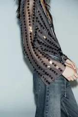 Body negro con escote en V cruzado, mangas largas acampanadas y apliques de lentejuelas.