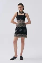 Vestido corto negro de tejido de punto con técnica jacquard, escote cuadrado, tirantes anchos y falda con estampado de árboles plateados.