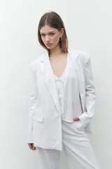 Blazer de lino color blanco, de corte oversize, con solapas de muesca y cierre con dos botones.