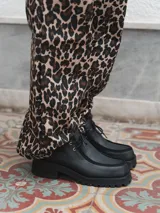 Zapato de cuero negro con cordones, detalle de pespuntes en la puntera y suela de goma con plataforma.