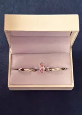 Set de tres anillos de plata 925, compuesto por un anillo solitario con piedra zirconia central tallada en corte marquesa de color rosado y dos alianzas lisas de diseño bombé.