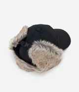 Gorra de estilo aviador con visera curva, confeccionada en poliéster negro. Presenta solapas laterales con forro de piel sintética para cubrir las orejas y ajuste trasero regulable.