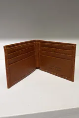 Billetera de cuero con diseño clásico y minimalista, con acabado brillante y logo grabado en la esquina inferior derecha.