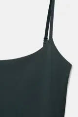 Vestido corto negro de corte ajustado, con escote recto y tirantes finos ajustables.