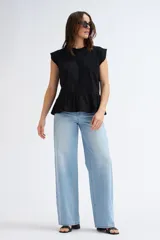 Camiseta sin mangas negra con cuello redondo, hombros estructurados y un volante peplum en la parte inferior.