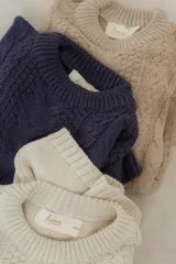 Buzo de tejido de punto con diseño de ochos, cuello redondo, mangas largas y corte holgado. Marca Irene.