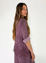 Camisa de manga larga color violeta, con cierre frontal de botones y detalle de encaje aplicado en el ruedo.