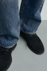Zapato tipo derby con cordones, confeccionado en piel con acabado de serraje. Presenta horma redonda y suela a contraste.