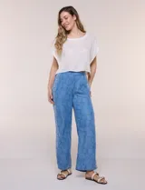 Pantalón wide leg de lyocell color azul con estampado paisley, cintura elástica y bolsillos laterales. Cuenta con una tira lateral decorativa con diseño ornamental.