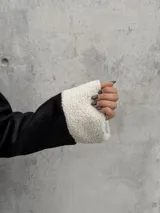 Campera tipo gamulán de color negro con interior y detalles de corderito en color blanco. Presenta cierre frontal, cuello clásico y dos bolsillos frontales.