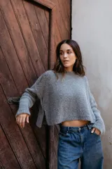 Buzo tejido en mohair de corte crop, con cuello redondo, mangas largas y tajos laterales en el ruedo.