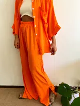 Pantalón de lino naranja de corte ancho con cintura elastizada y aberturas laterales en el ruedo.