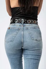 Pantalón de jean estilo campana con tiro alto, confeccionado en denim con elastano. Presenta un lavado claro y corte ajustado en la parte superior que se ensancha desde la rodilla hacia el ruedo.