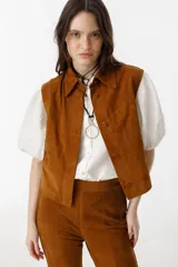 Chaleco marrón de gamuza con cuello camisero, botones escondidos y apliques tribales.