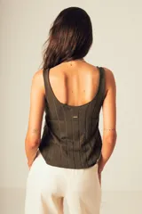 Musculosa de tejido canalé color verde oscuro, confeccionada en 100% algodón, con escote redondo y calce que acompaña el cuerpo.