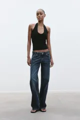 Top de punto con cuello halter y escote redondo profundo, sin mangas y corte ajustado.