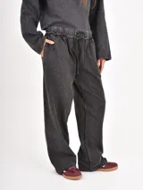 Pantalón de corte holgado con efecto lavado, cintura elástica con cordón ajustable y bolsillos laterales.