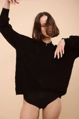 Campera de punto con cierre frontal, diseño de rayas horizontales en tonos verde, verde oscuro y rojo, y textura ondulada en el tejido.