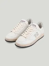 Championes de cuero color blanco con detalles de glitter plateado en el talón y logo de la marca en la lengüeta.